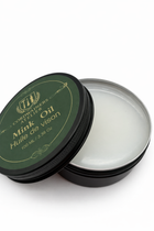 Open container of Mink Oil with green lid on a white background
